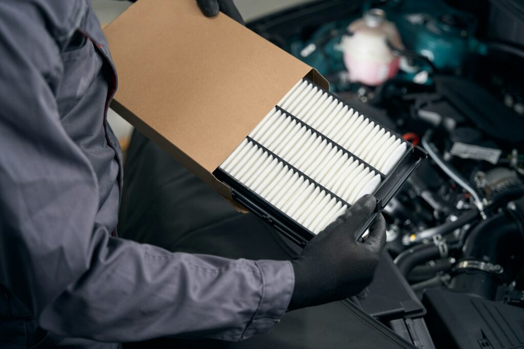 Mechanic holding parts for car repair in workshop